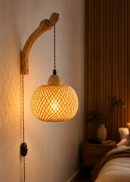 Natural rattan and bamboo wall lantern lit in a cozy bedroom corner